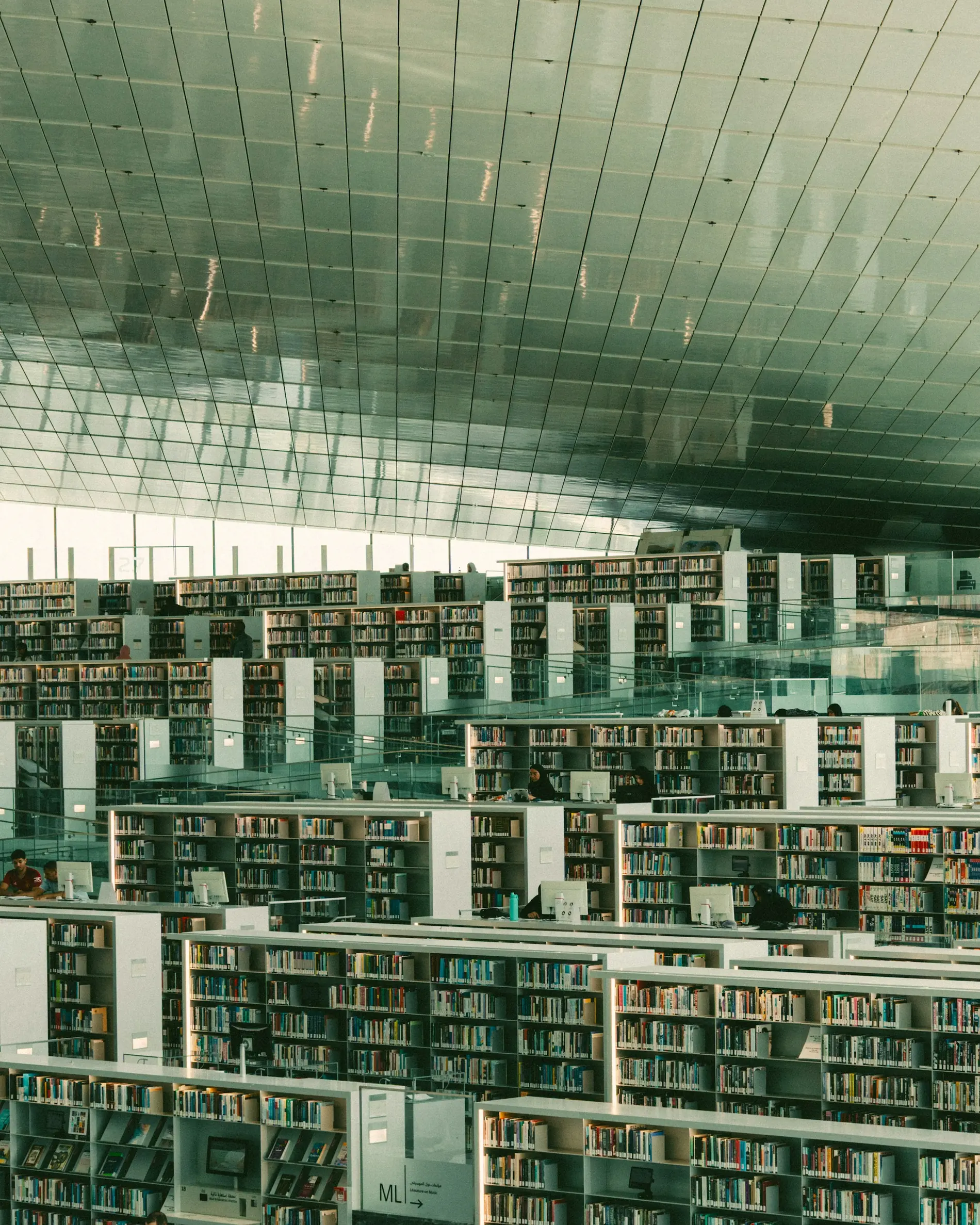 A multi-level research library with ordered collections and quiet workspaces
